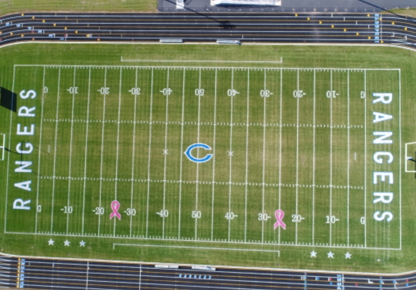 Pink Breast Cancer Ribbon Stencils Painted on Football Field